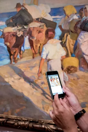 Main et téléphone devant tableau sortant le bateau Sorolla